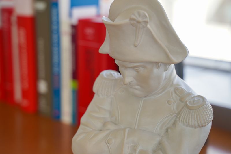 Statuette blanche en bicorne devant les codes rouges du cabinet